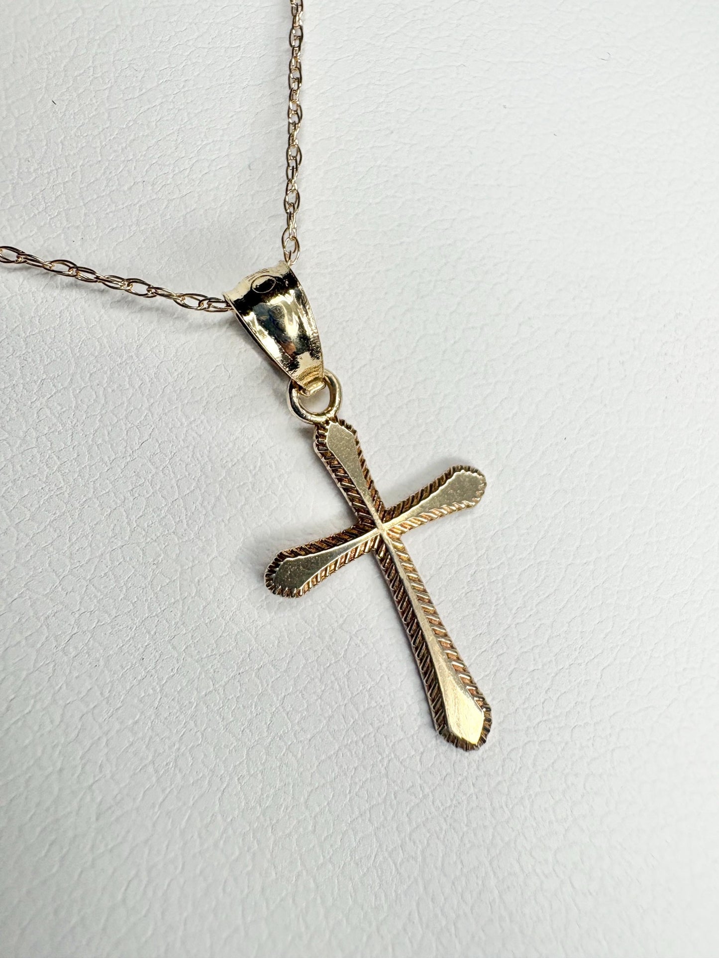 Solid 10k gold cross pendant necklace with a fine rope chain.