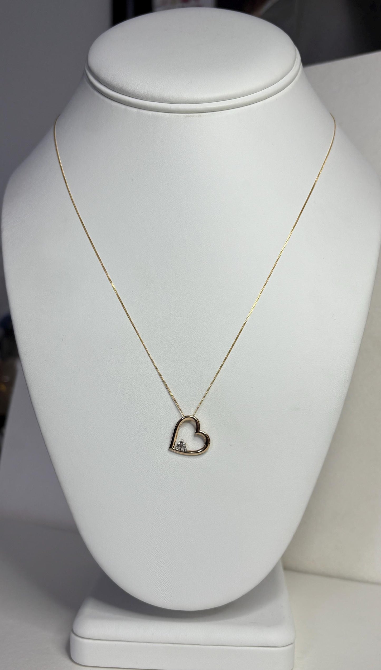 A 10k gold heart pendant with a diamond chip on an 18-inch 9k gold chain.