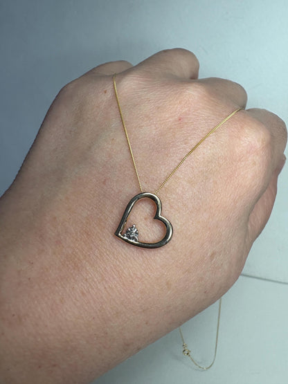 A 10k gold heart pendant with a diamond chip on an 18-inch 9k gold chain.