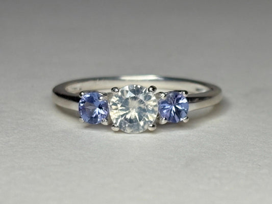 Sterling silver ring with a central off-white zircon and two tanzanite stones.