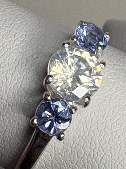 Sterling silver ring with a central off-white zircon and two light purple tanzanites.