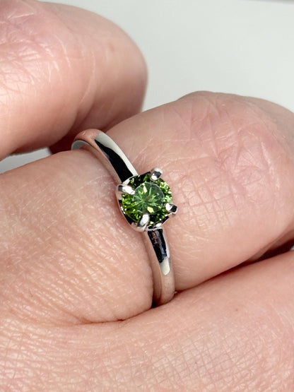 Sterling silver ring with a round green tourmaline gemstone.