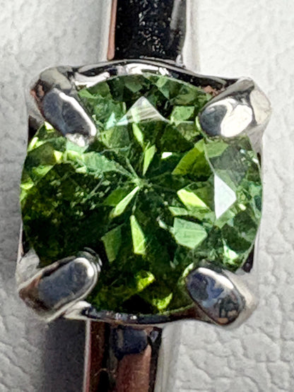 Sterling silver ring with a round, green tourmaline gemstone.