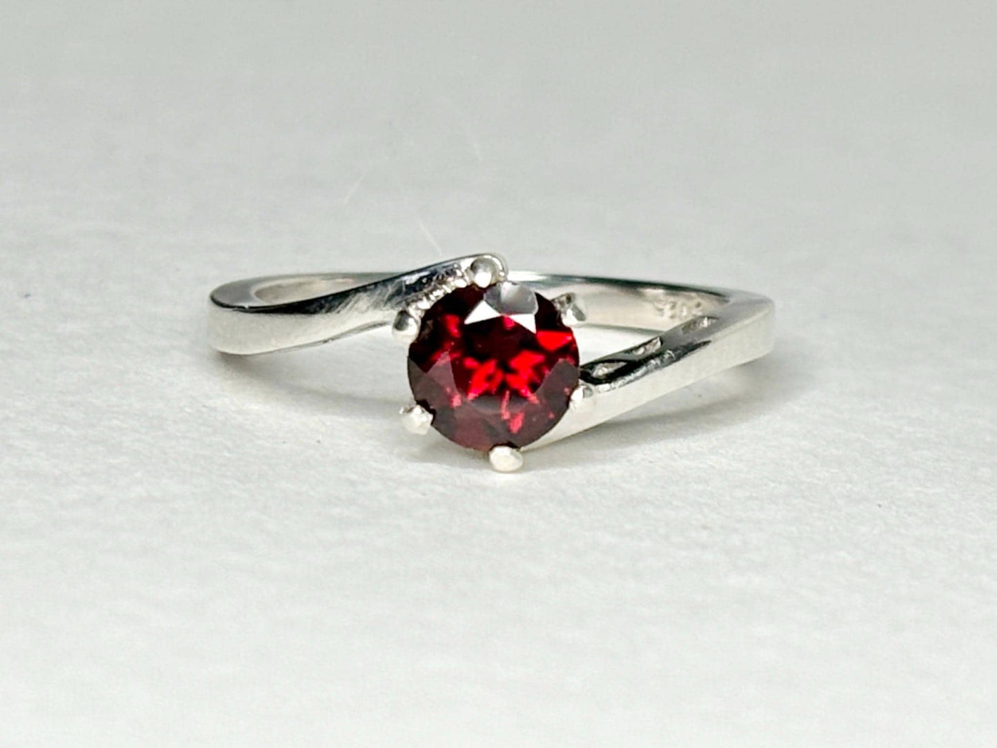 Sterling silver bypass ring with a round pyrope garnet.