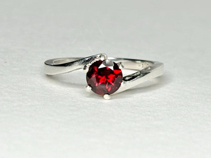 Sterling silver bypass ring with a round pyrope garnet.