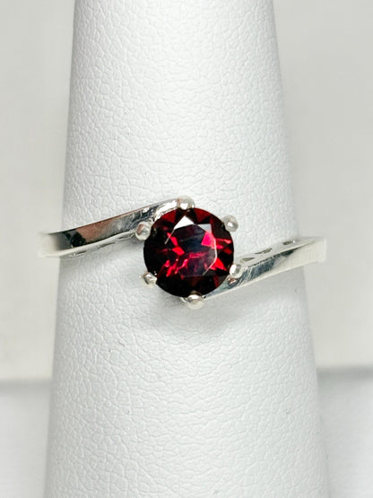 Sterling silver bypass ring with a round pyrope garnet.