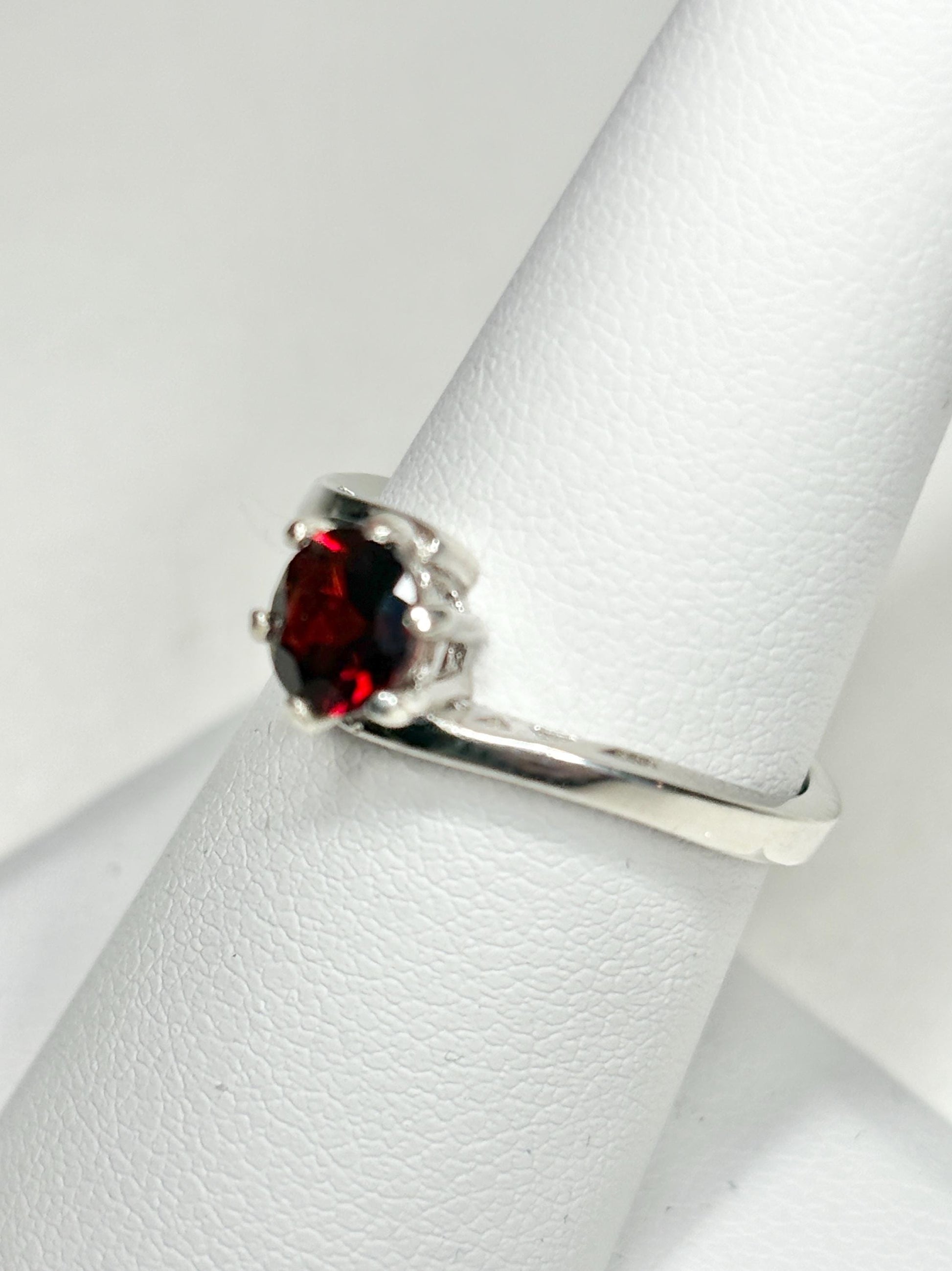 Sterling silver bypass ring with a round pyrope garnet.