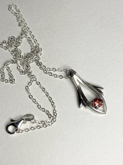 Sterling silver necklace with a light red Oregon sunstone pendant.