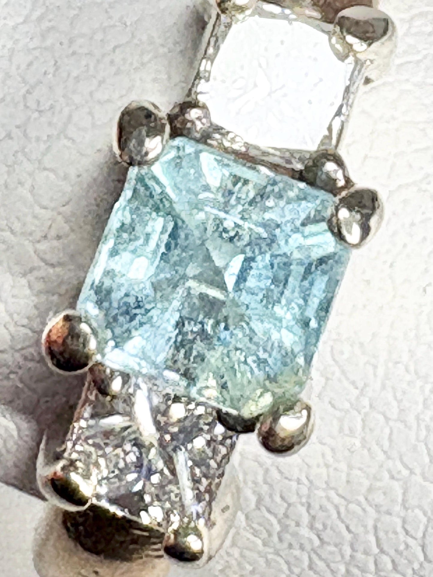 A blue asscher cut tourmaline ring with diamond accents in gold.