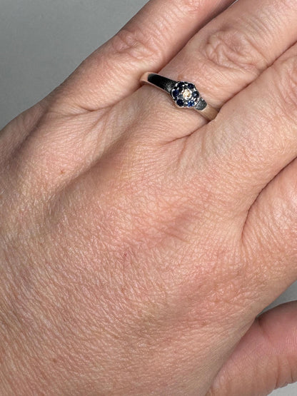 Sterling silver ring with a central gold sapphire and blue sapphire daisy halo.