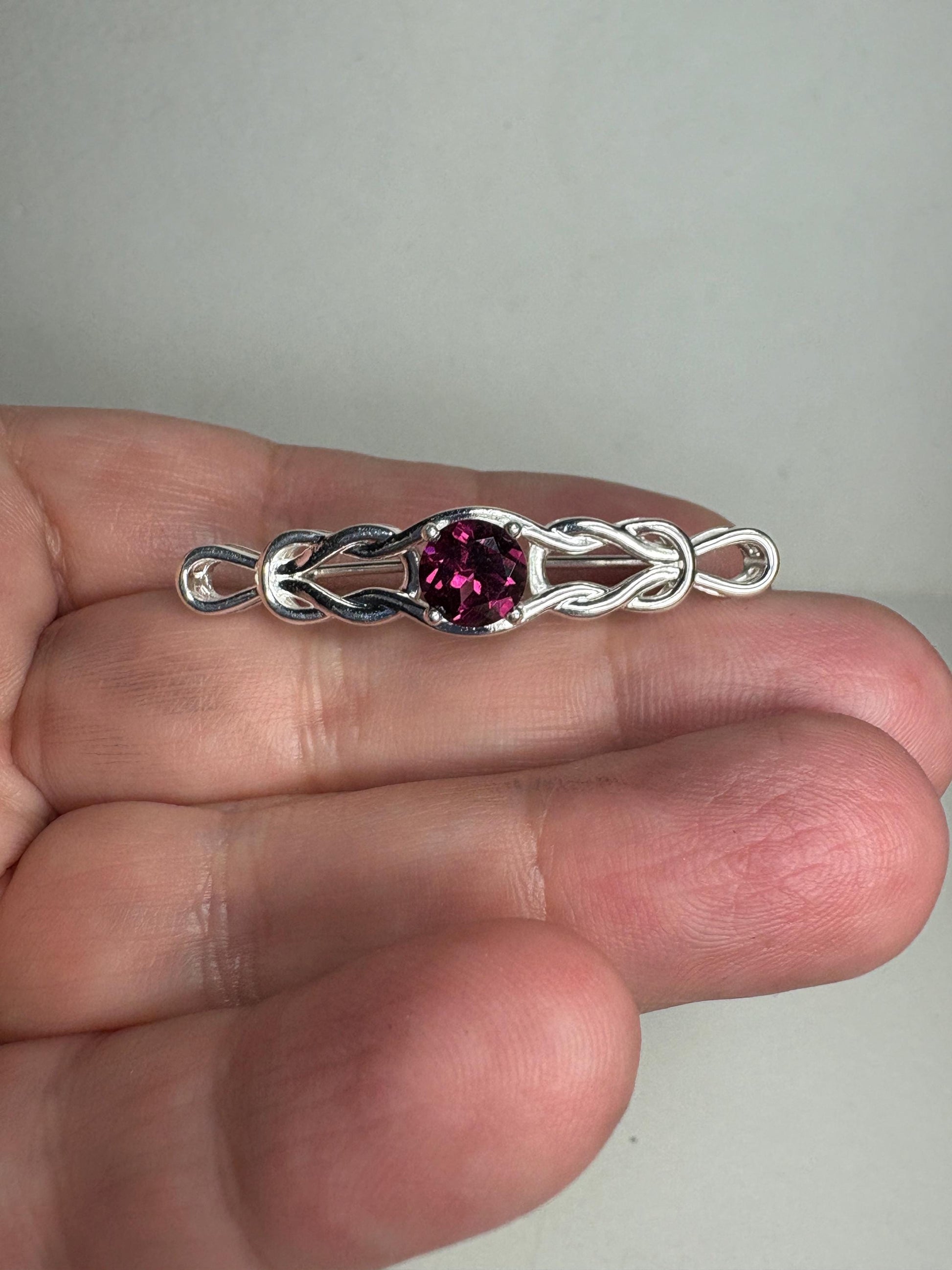 Sterling silver bar brooch with a rhodolite garnet and Celtic knot design.