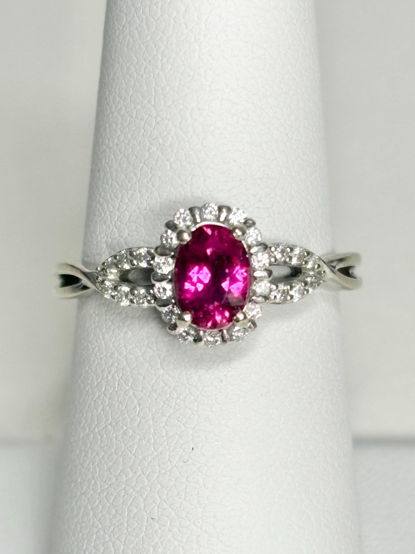 Oval rubellite tourmaline and diamond halo ring in 10k white gold.