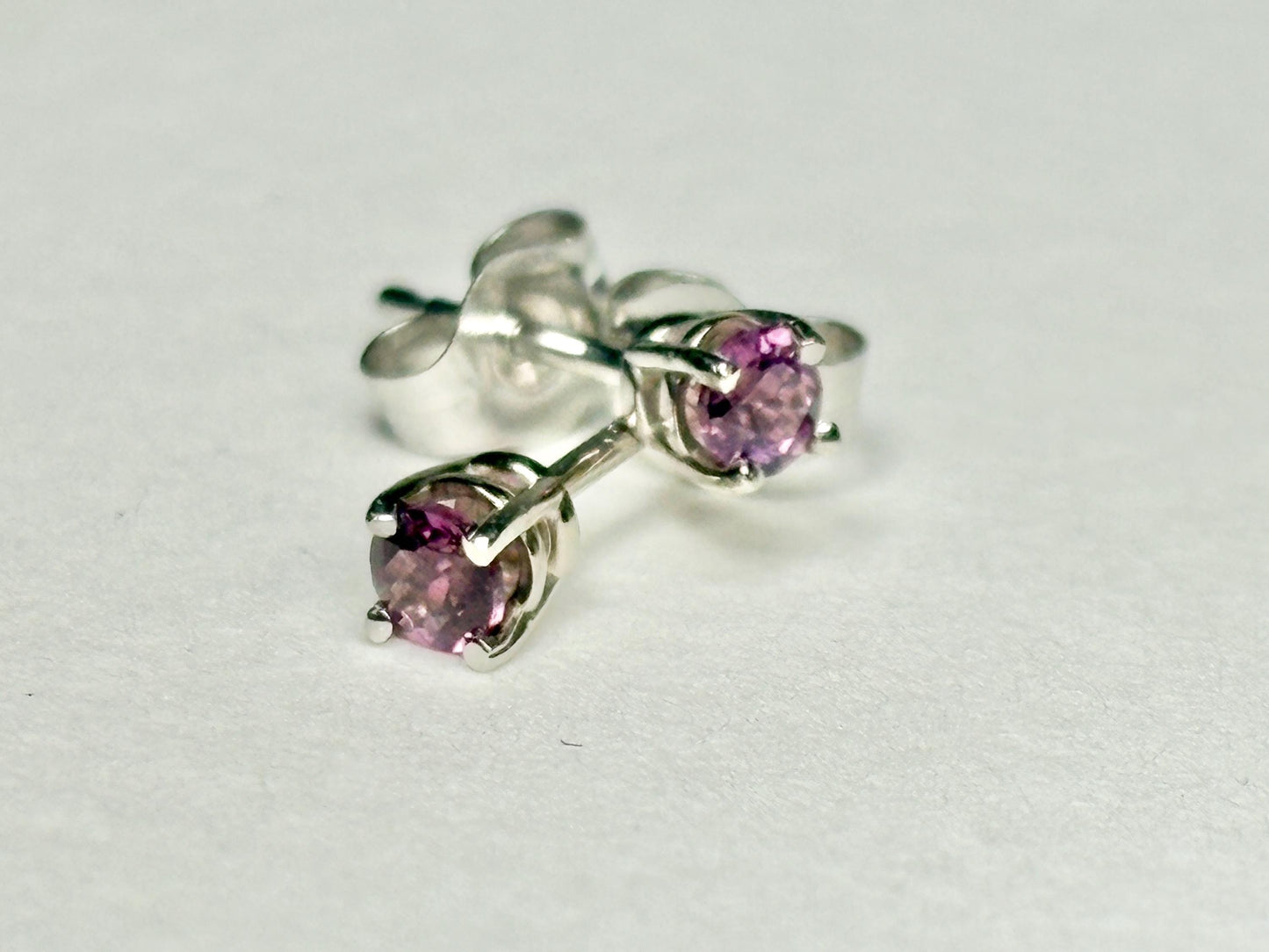 Pair of 14k white gold stud earrings with round rhodolite garnets.