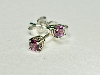 Pair of 14k white gold stud earrings with round rhodolite garnets.