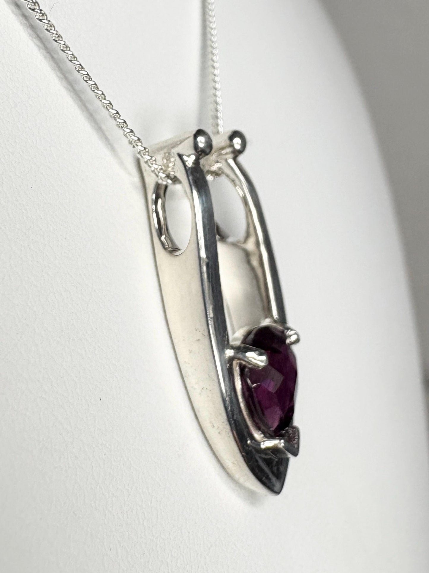 Sterling silver pendant necklace with a pear-shaped rhodolite garnet.
