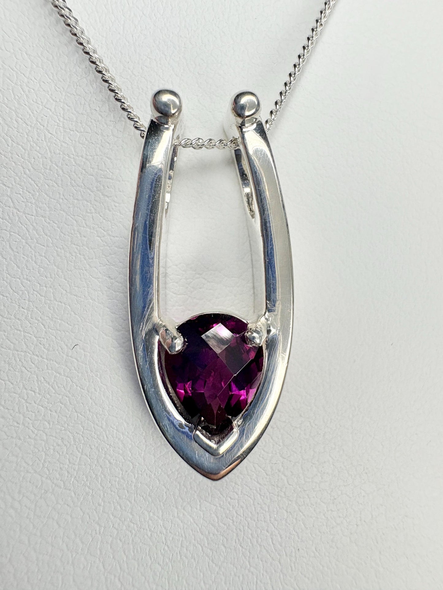 Sterling silver pendant necklace with a pear-shaped grape rhodolite garnet.