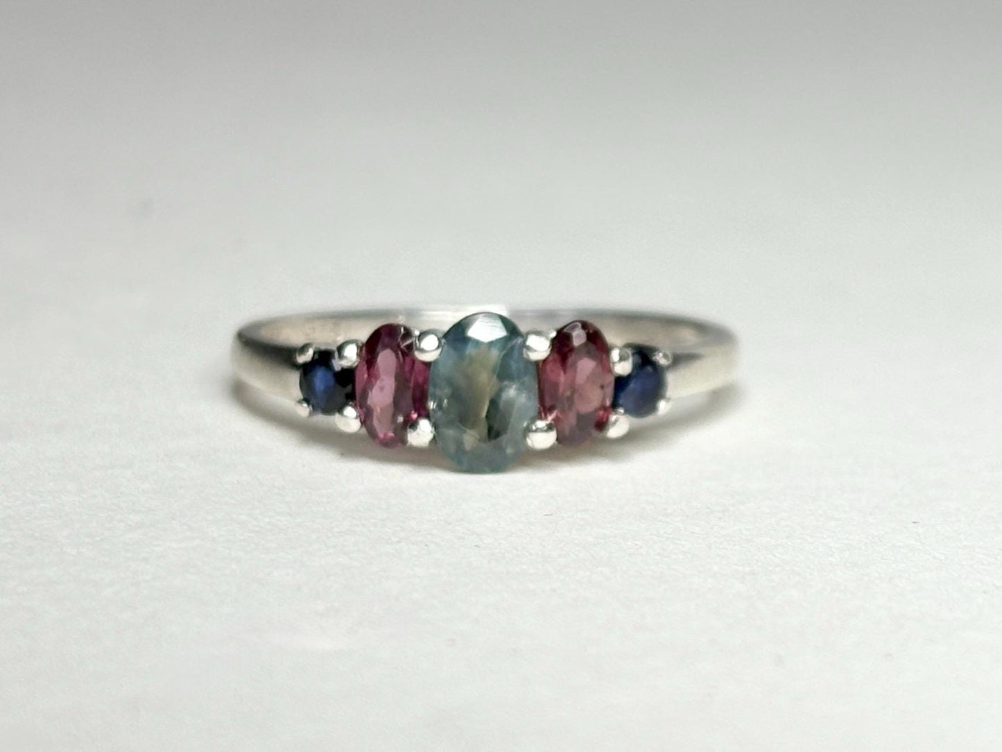 Sterling silver band ring with oval alexandrite, rhodolite garnets, and blue sapphires.