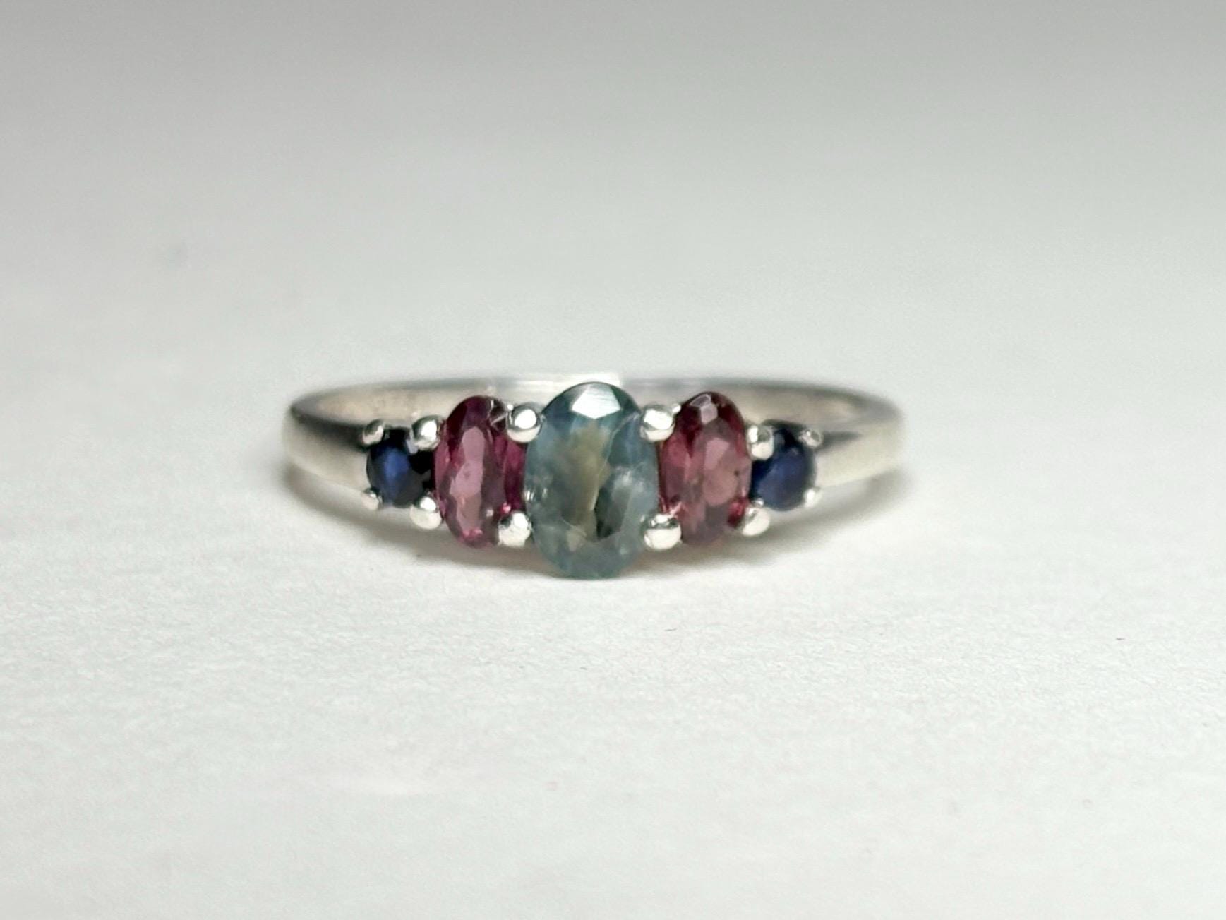Sterling silver band ring with oval alexandrite, rhodolite garnets, and blue sapphires.