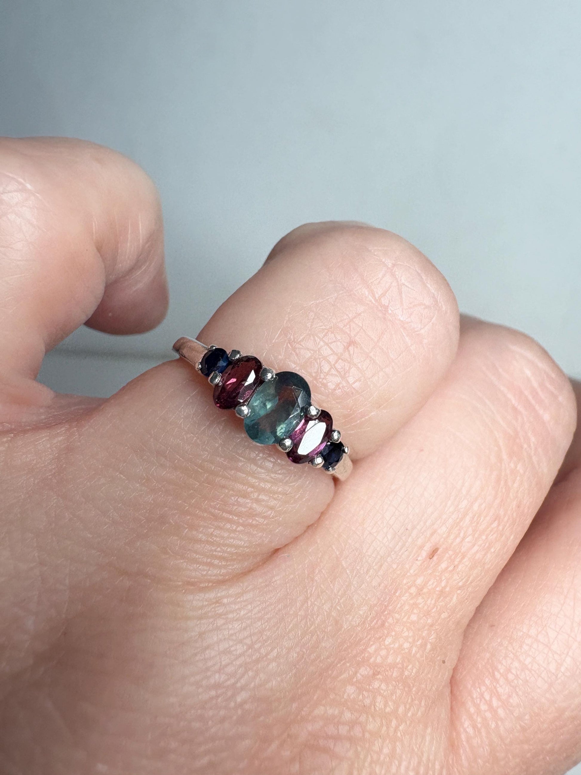 Sterling silver band ring with oval alexandrite, rhodolite garnets, and blue sapphires.