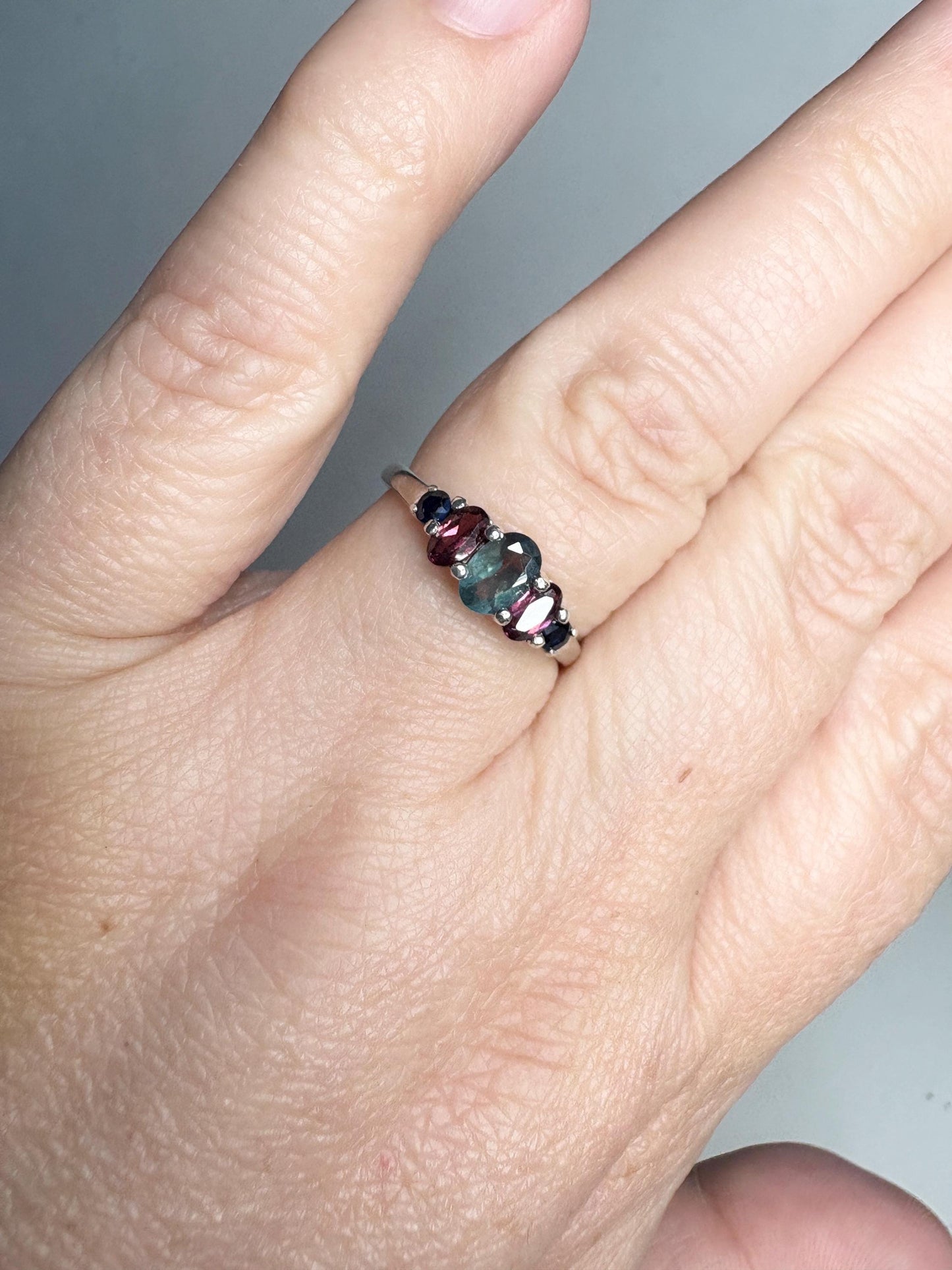 Sterling silver ring with oval alexandrite, rhodolite garnets, and blue sapphires.