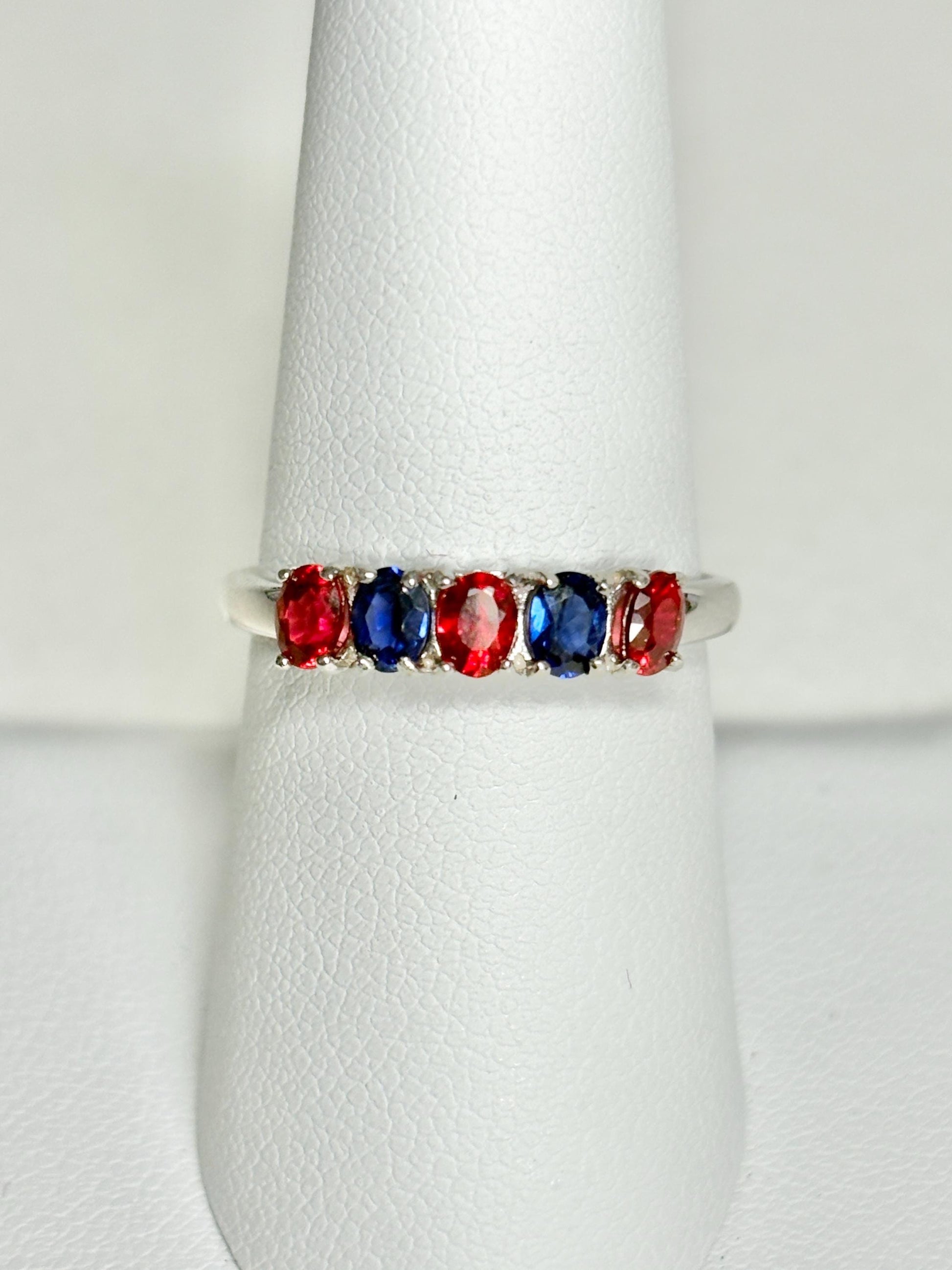 Sterling silver band ring with oval red and blue sapphires.
