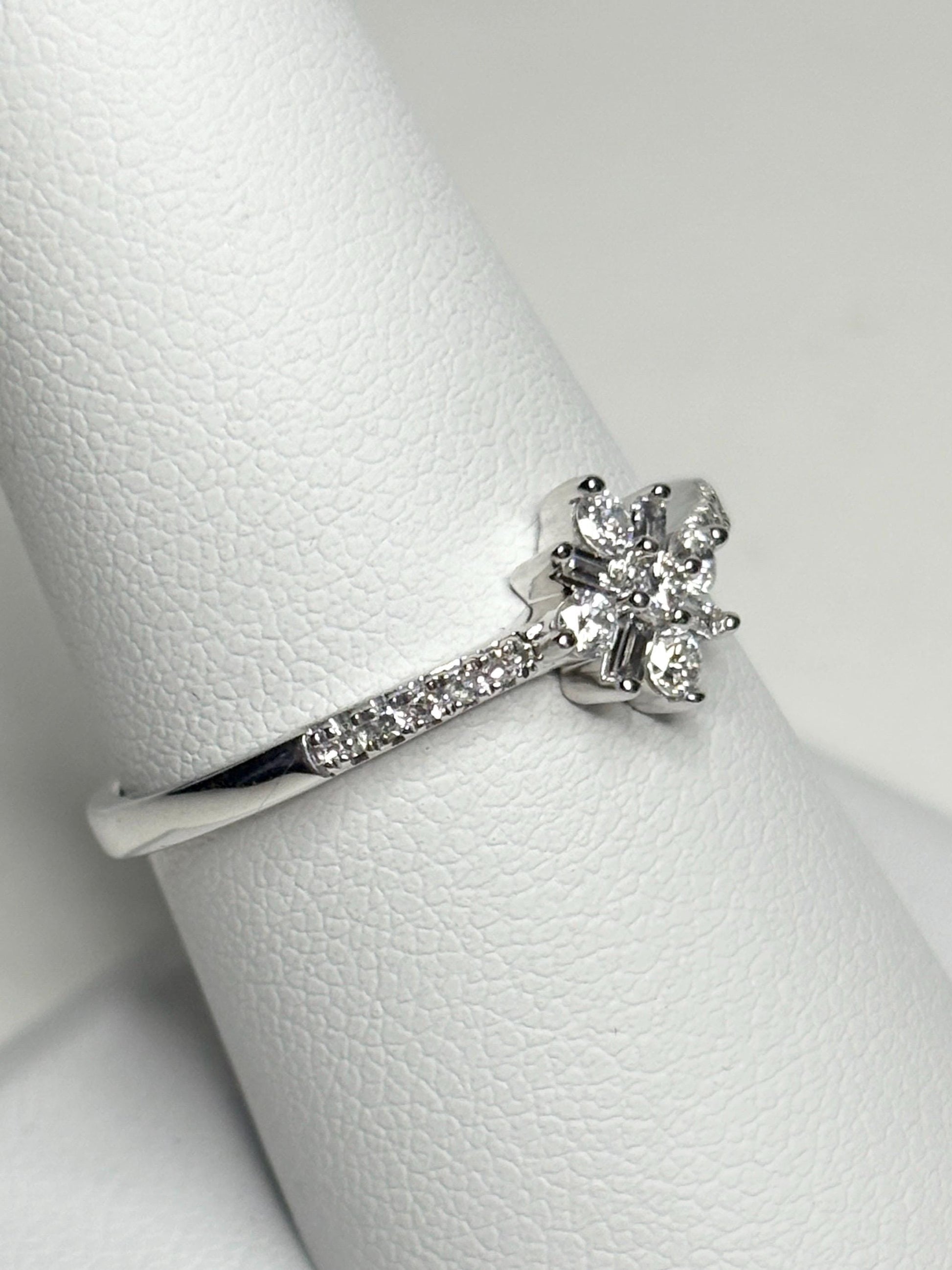 A white gold ring with a starburst design of baguette and round diamonds.