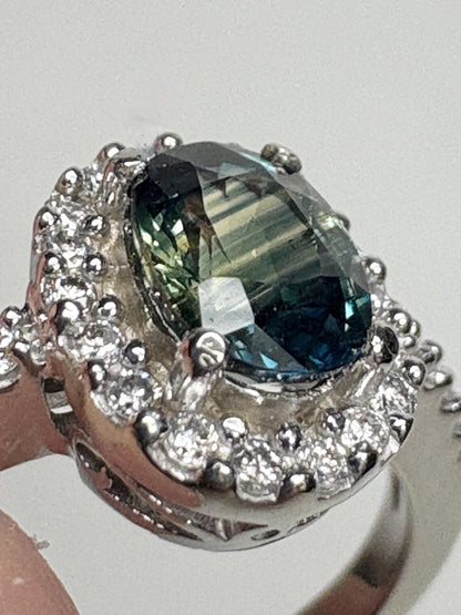 Oval bi-color sapphire and diamond halo ring in 10k white gold.