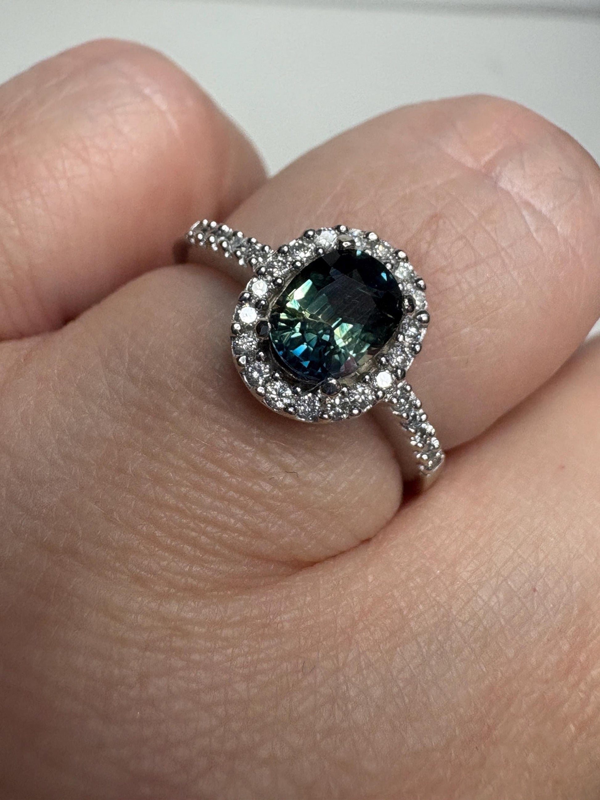 Oval bi-color sapphire and diamond halo ring in 10k white gold.