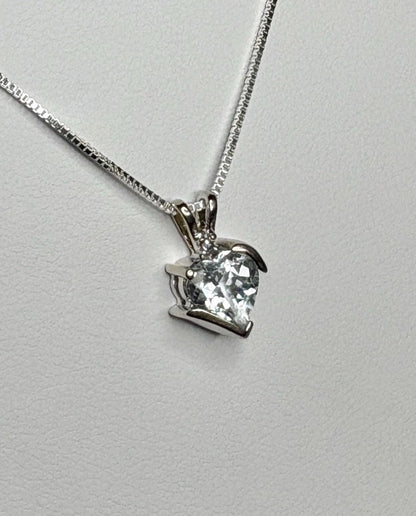A white gold heart pendant with an aquamarine and diamond on a silver chain.