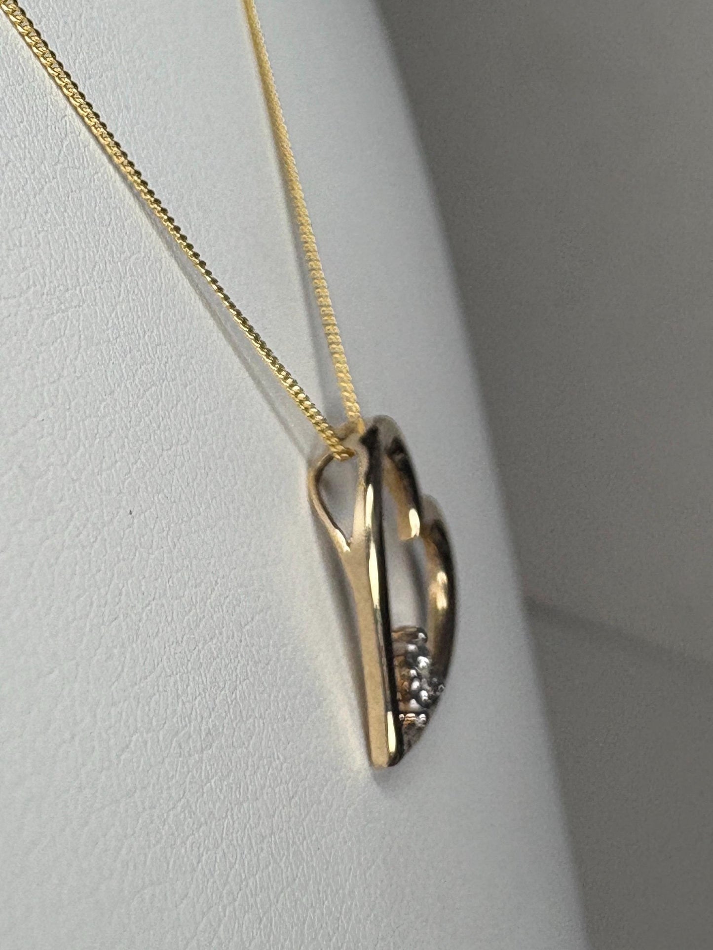 A gold heart pendant with diamonds on an 18-inch gold chain.