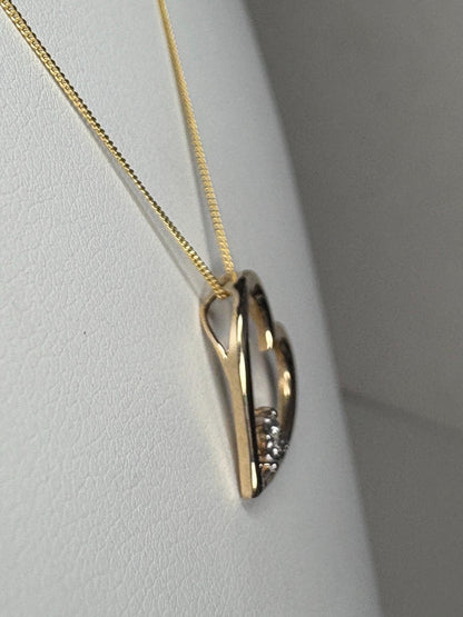 A gold heart pendant with diamonds on an 18-inch gold chain.