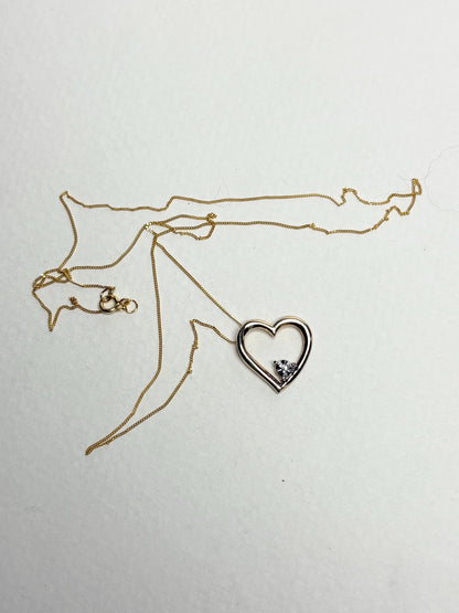 A gold heart pendant with a diamond chip on an 18-inch gold chain.