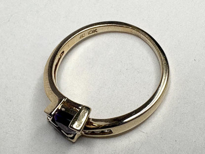 A 10k yellow gold ring with a trillion amethyst and channel-set diamonds.