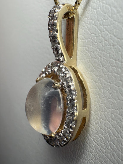 A blue sheen moonstone pendant with a diamond halo in 10k gold.