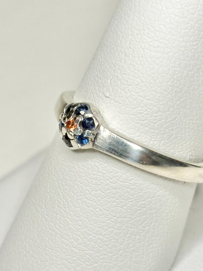 Sterling silver ring with a central gold sapphire and blue sapphire halo.