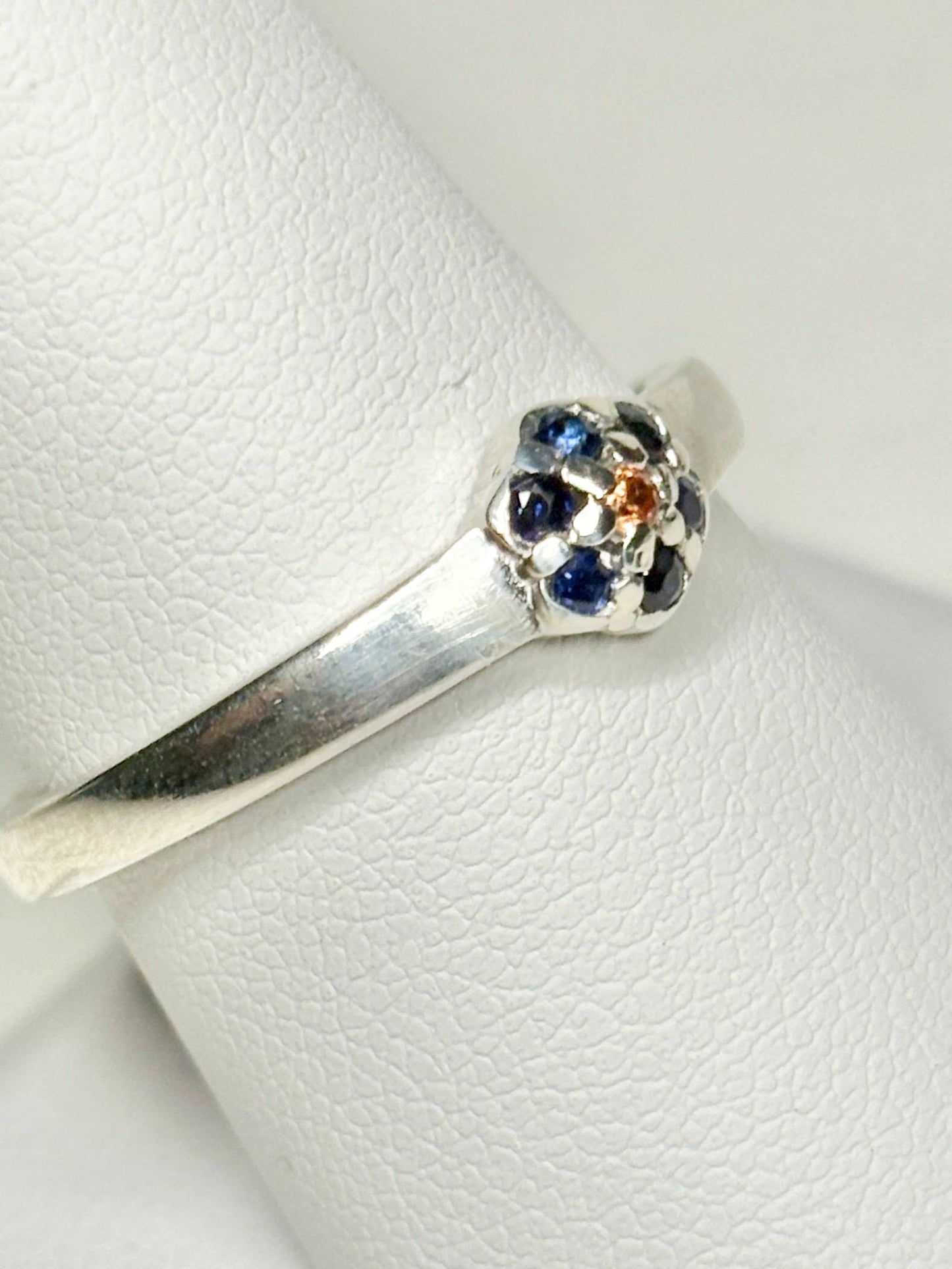 Sterling silver ring with a gold sapphire center and blue sapphire halo.