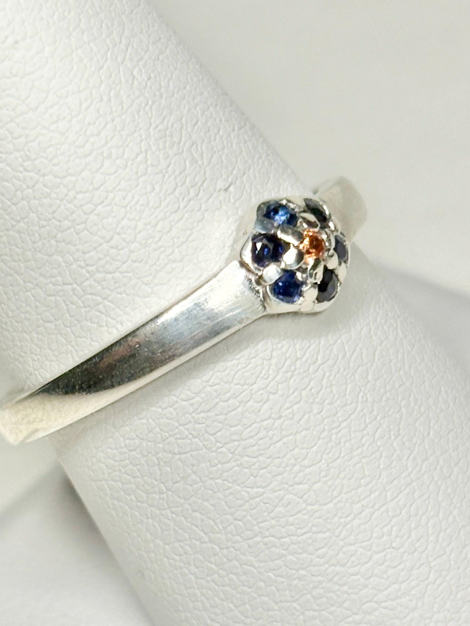 Sterling silver ring with a gold sapphire center and blue sapphire halo.