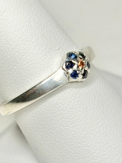 Sterling silver ring with a gold sapphire center and blue sapphire halo.