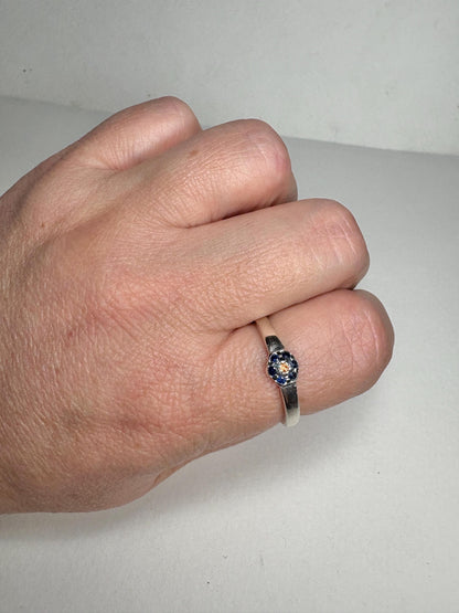 Sterling silver ring with a central gold sapphire and blue sapphire halo.