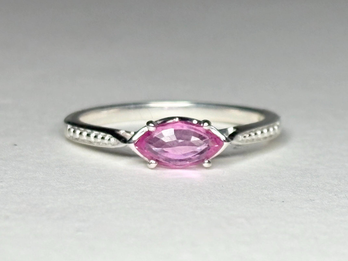 Sterling silver ring with a pink marquise sapphire set east-west.