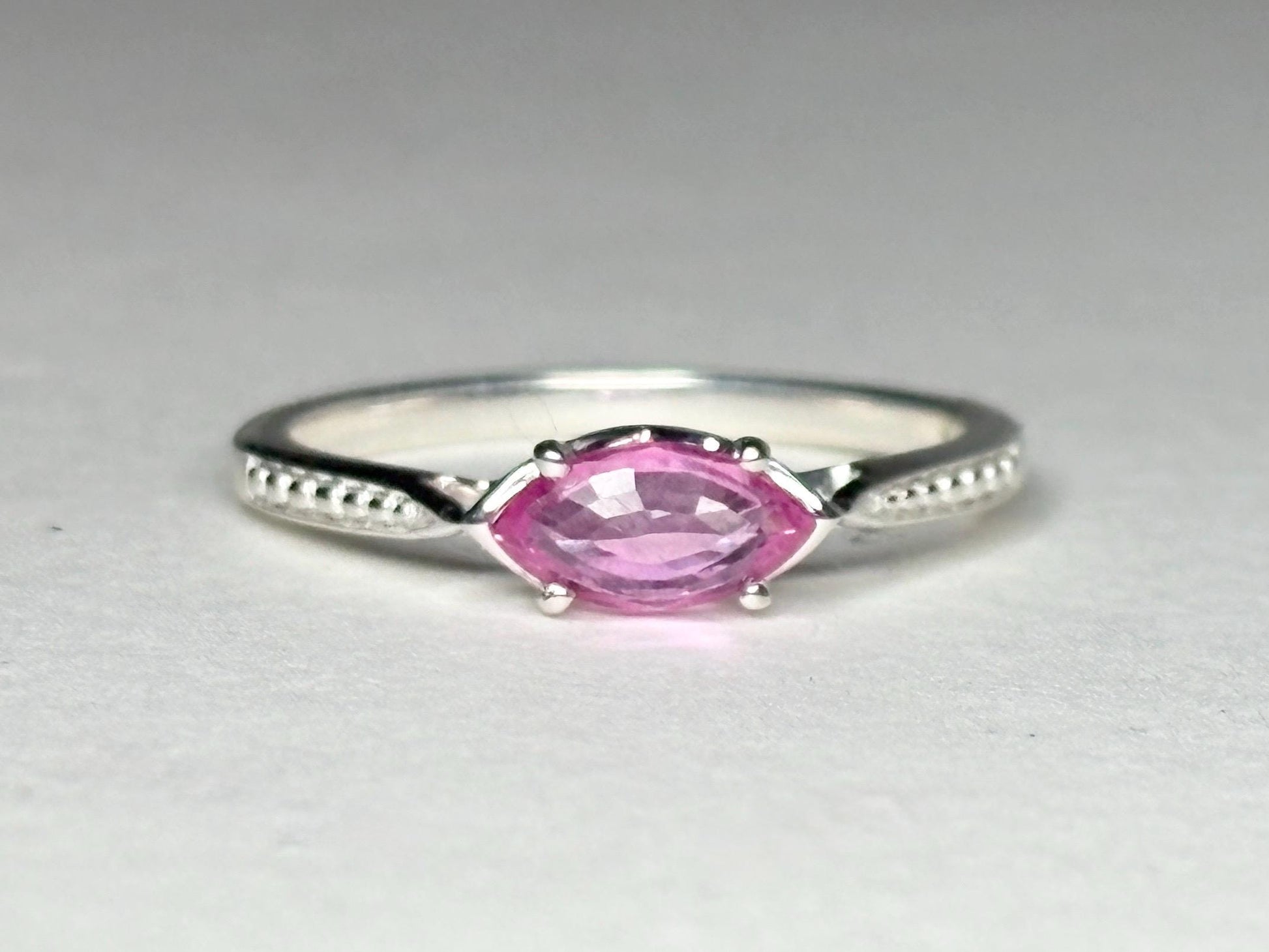 Sterling silver ring with a pink marquise sapphire set east-west.