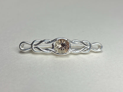 Sterling silver bar brooch with a Celtic knot design and a round light peach Oregon sunstone.