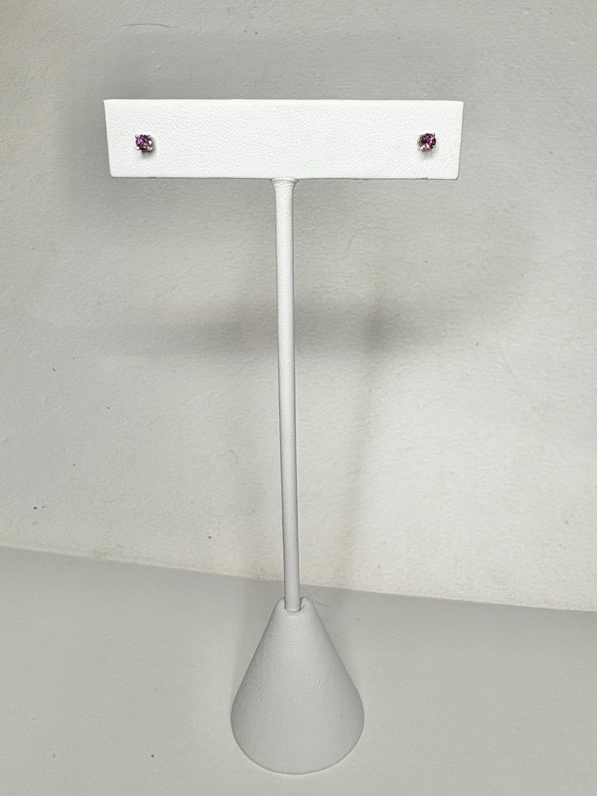 Two small, round rhodolite garnet stud earrings set in 14k white gold.