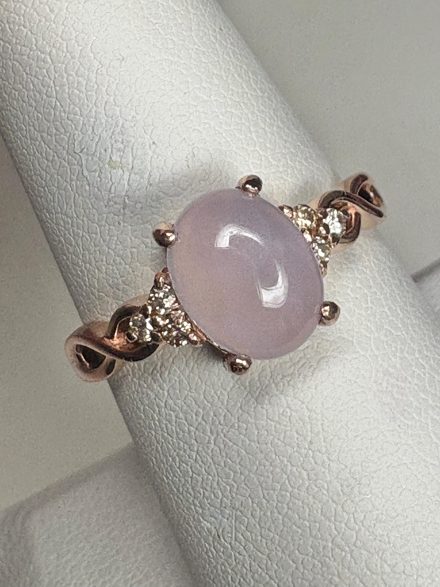 A rose gold ring with a oval blue agate and diamonds.