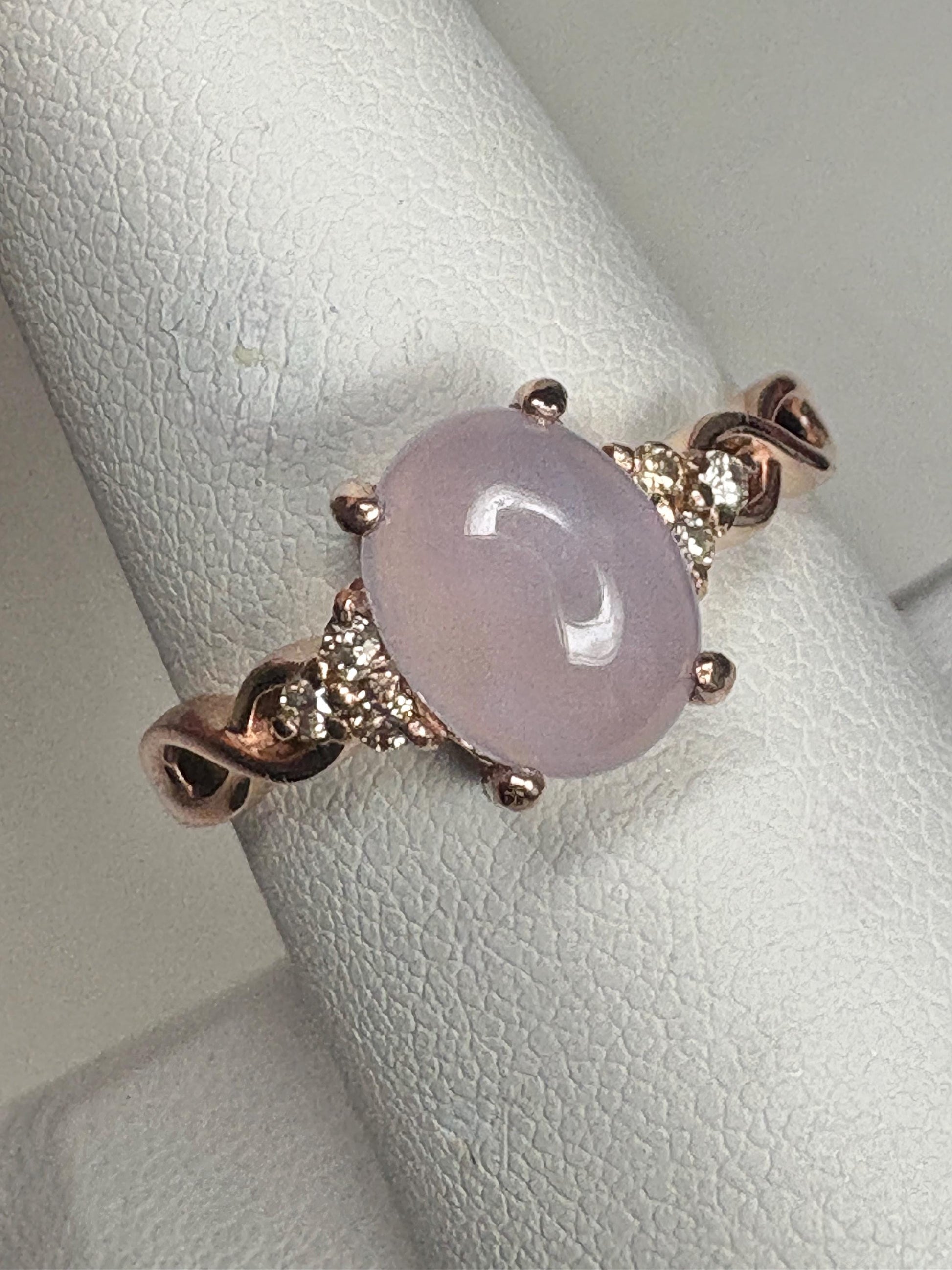 A rose gold ring with a oval blue agate and diamonds.