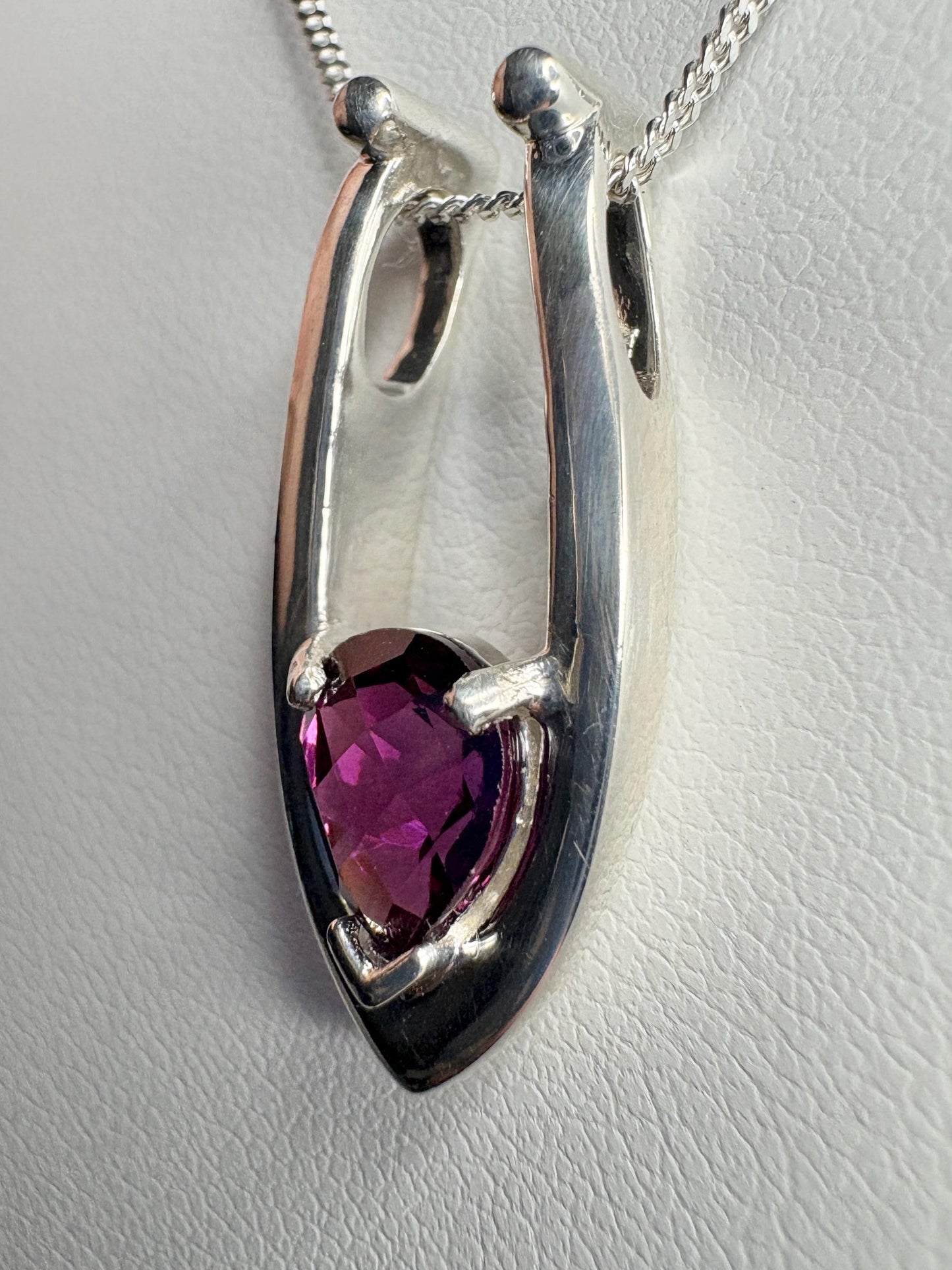 Sterling silver pendant necklace with a pear-shaped grape rhodolite garnet.