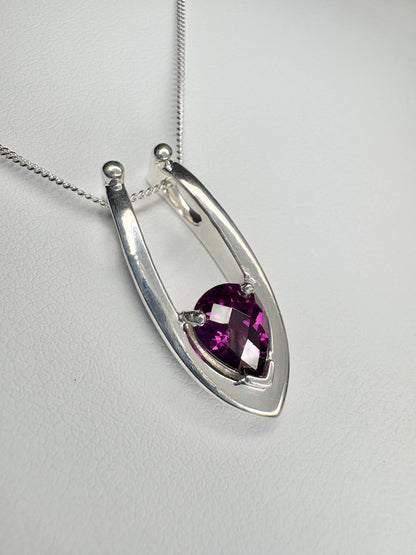 Sterling silver pendant necklace with a pear-shaped grape rhodolite garnet.
