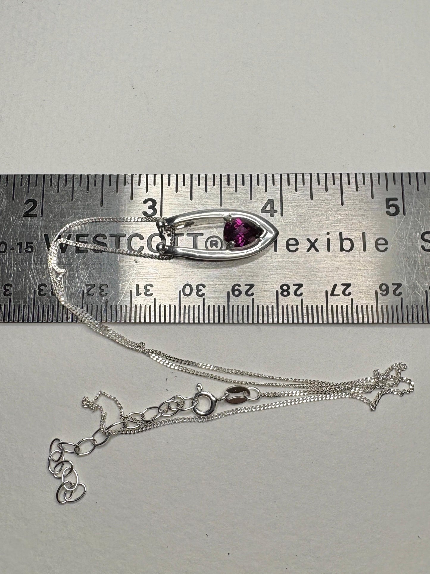 Sterling silver pendant necklace with a pear-shaped rhodolite garnet on an adjustable chain.