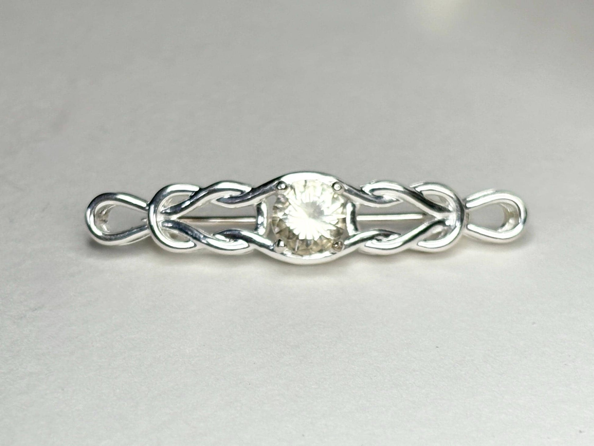 Sterling silver brooch with a yellow Oregon sunstone and Celtic knot design.