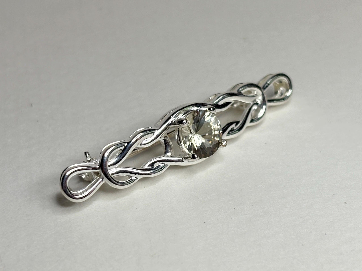 Sterling silver brooch with a Celtic knot design and a round yellow Oregon sunstone.